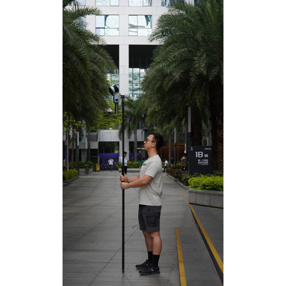 a surveyor using the XGRIDS K1 extension pole kit modular system for elevated mobile LiDAR mapping and survey-grade stability in a business park with XGRIDS Lixel L2 attached 