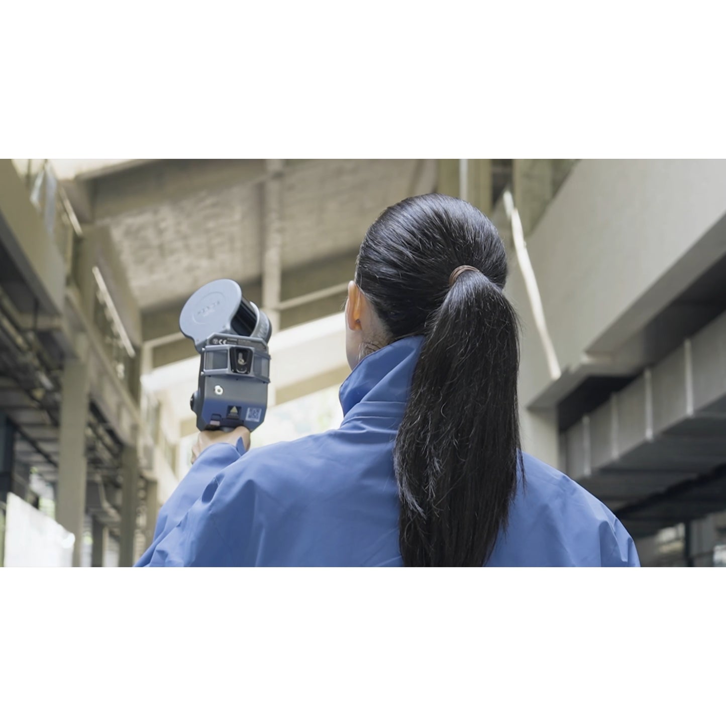 surveyor using XGRIDS Lixel L2 Pro real-time RTK SLAM LiDAR scanner for scanning the inside of a business complex in low light