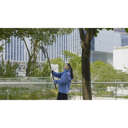 the surveyor using the extension pole attached to the XGRIDS Lixel L2 Pro real-time RTK SLAM LiDAR scanner for better vertical scanning accuracy using it to scan in a park with trees and vegetation